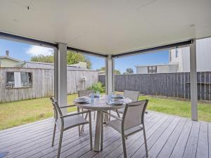 a patio with a table and chairs on a deck at Soleil Studio - Whangamata Self-contained Unit in Whangamata