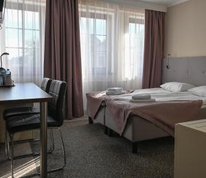 a bedroom with a bed and a desk and windows at Hotel Kolorowa in Karpacz +106 photos