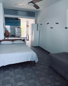 a bedroom with a white bed and a refrigerator at Tolo in Tolo