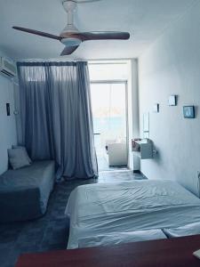 a bedroom with a bed and a ceiling fan at Tolo in Tolo