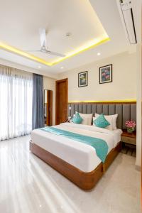 a bedroom with a large bed with blue pillows at S by Z Hotels, Baani Square in Gurgaon +19 photos