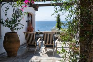a patio with chairs and a table and a potted plant at Liogerma Boutique Home in Skiathos