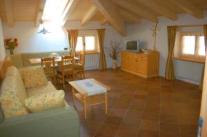 een woonkamer met een bank en een tafel bij Residence Ca' Delle Margherite in Pellizzano