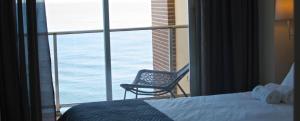 a room with a bed and a chair in front of a window at Apartamentos Santa Clara in Calpe