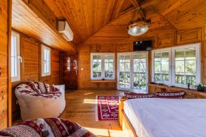 a bedroom with a bed and a couch and windows at Ferma Gold by PikHost in Tirana
