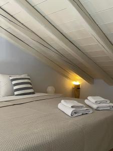 a bedroom with a bed with towels on it at Vivi's Apartments Loft in Spetses