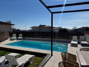 a swimming pool with chairs and a table and a table at casa santa caterina in Torroella de Montgrí