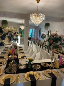 a long dining room with white chairs and a long table at Hotelik Zielonka in Zielonka