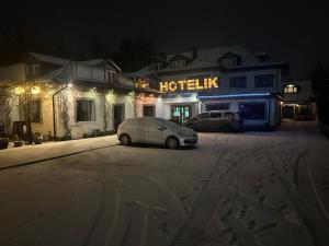 a car parked in front of a hotel at night at Hotelik Zielonka in Zielonka