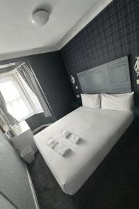 a bedroom with a large white bed with a window at Silversands Hotel in Blackpool