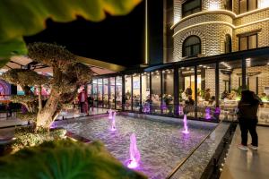 a fountain in the middle of a shopping mall at night at Si'Hana Hotel in Elbasan