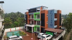 a building with cars parked in front of it at Lotus Beach Resort in Nagaon