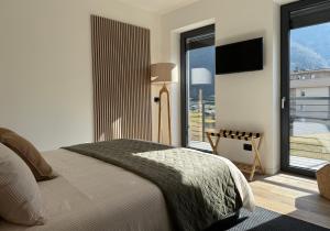 a bedroom with a bed and a large window at CT Executive Rooms, Lake Como and Valtellina in Dubino