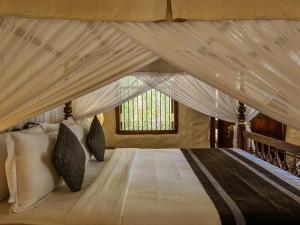 a bedroom with a canopy bed with white sheets and pillows at Heenatigala Walawwa - Free Shuttle to Our Private Beach in Talpe +31 photos