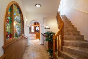 a hallway with a staircase with a stained glass window at Hajdú Kastély Hotel in Hajdúszoboszló