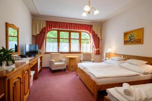 a bedroom with two beds and a desk and a television at Hajdú Kastély Hotel in Hajdúszoboszló +69 photos