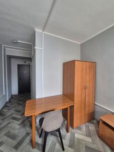 a wooden desk and a chair in a room at Альтаир in Almaty