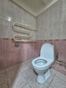 a bathroom with a white toilet in a room at Альтаир in Almaty