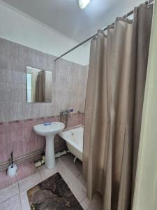 a bathroom with a sink and a toilet and a tub at Альтаир in Almaty