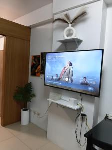 a flat screen tv on a wall in a room at Shell Residences MOA by Joseph in Manila