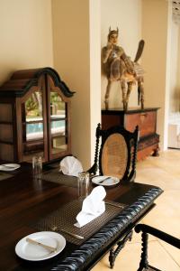 a dining room table with a chair and a statue of a camel at Heenatigala Walawwa - Free Shuttle to Our Private Beach in Talpe