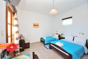 a bedroom with two beds and a couch at Pension Sofia Amorgos-Katapola in Katapola
