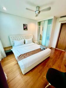 a large white bed in a room with wooden floors at Apartment klcc area in Kuala Lumpur +7 photos