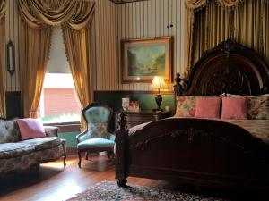 a bedroom with a large bed and a chair at The Queen Anne Bed & Breakfast in Natchitoches