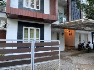 a house with a motorcycle parked in front of it at Orchid Woods in Trivandrum