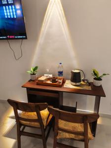 a desk with two chairs and a table with a tv at The Continental Hotel in Seeduwa