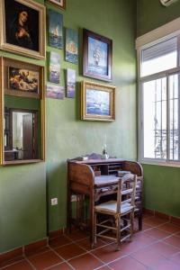 a green room with a table and a chair at La Posada de Zepeda in Jerez de la Frontera