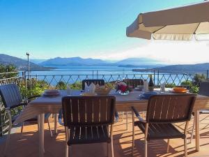 a wooden table with chairs and a view of the water at Villa Ametista in Meina