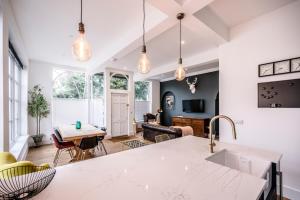 a kitchen with a table and a living room at The Leiston, High Street in Leiston