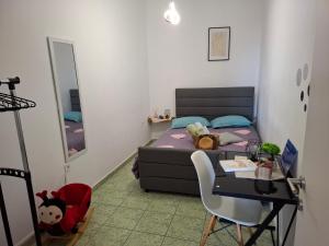 ein kleines Schlafzimmer mit einem Bett, einem Tisch und einem Schreibtisch in der Unterkunft Le Rocher 2 in Ermoupoli