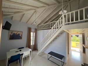 a room with a staircase and a table and chairs at Vivi's Apartments Loft in Spetses