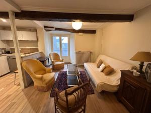 a living room with a couch and a table at Murat - La maison de la petite place in Murat