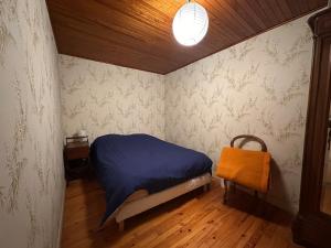 a bedroom with a bed with a blue comforter at Murat - La maison de la petite place in Murat