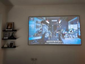 a flat screen tv hanging on a wall at Chihiro Haven in Chongqing