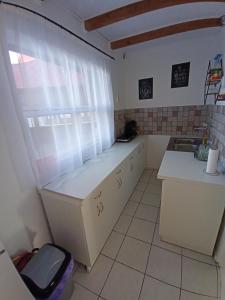 a small kitchen with a counter and a window at Plázs Vendégházak 1 ,2 in Tiszafüred