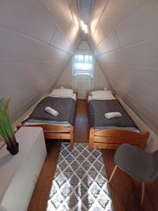 two beds in a small room in a tiny house at Plázs Vendégházak 1 ,2 in Tiszafüred