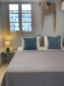 a bedroom with a large bed with blue pillows at Vivi's Apartments Loft in Spetses