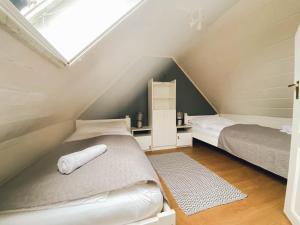 a attic bedroom with two beds and a skylight at Plázs Vendégházak 1 ,2 in Tiszafüred +6 photos