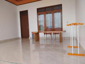 a room with two chairs and a table and windows at Toba Sunset in Tuktuk Siadong