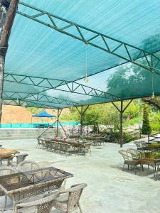 a group of tables and chairs under a blue canopy at Green Veranda in Nurekata