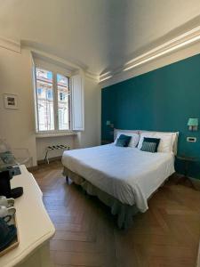 a bedroom with a large bed with a blue wall at XX SETTEMBRE Urban Relais in Turin