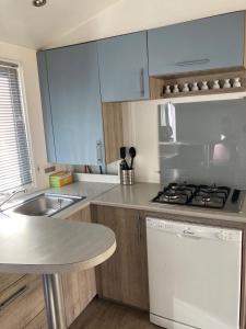 a kitchen with white cabinets and a stove top oven at Chez Maxime - E33 - Clim TV Lave-vaisselle - Proche Europa Park et Rulantica in Boofzheim +7 photos