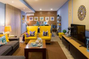 a living room with yellow chairs and a tv at Near beach and Oporto in Vila Nova de Gaia