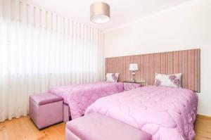 two beds in a room with pink sheets at Near beach and Oporto in Vila Nova de Gaia