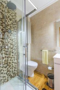 a bathroom with a toilet and a glass shower at Near beach and Oporto in Vila Nova de Gaia +19 photos