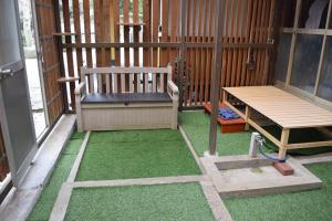 a screened in porch with a bench and grass at やぎみちの家 yagimichi-noie in Sasebo
